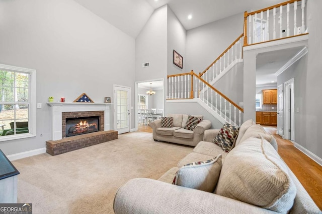 carpeted living room featuring a fireplace, a high ceiling, and ornamental molding