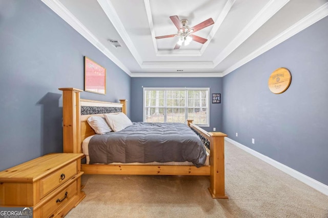 carpeted bedroom featuring ceiling fan, ornamental molding, and a tray ceiling