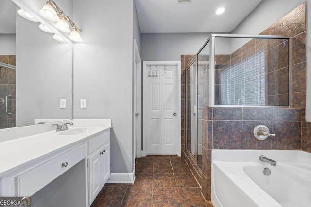 bathroom featuring shower with separate bathtub, vanity, and tile patterned floors