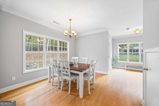 dining area featuring a notable chandelier, plenty of natural light, crown molding, and light hardwood / wood-style flooring