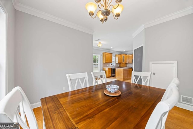 dining space featuring crown molding and light hardwood / wood-style floors