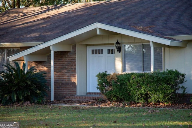 view of exterior entry featuring a lawn