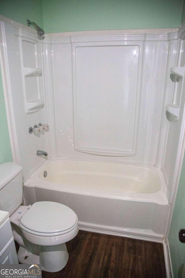 bathroom featuring toilet, wood-type flooring, and bathtub / shower combination