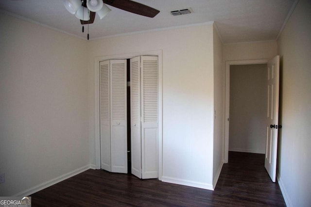 unfurnished bedroom featuring dark hardwood / wood-style floors, a closet, ornamental molding, and ceiling fan