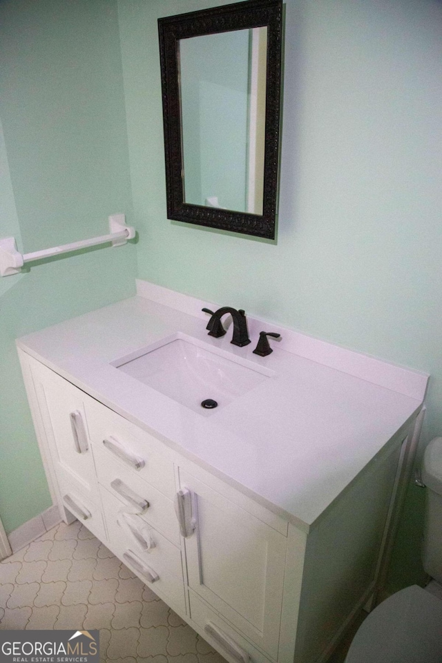 bathroom featuring tile patterned floors, vanity, and toilet