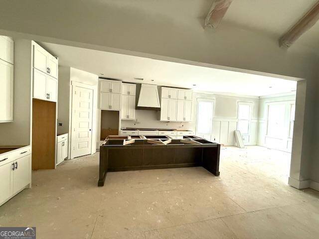 kitchen featuring white cabinets and custom range hood