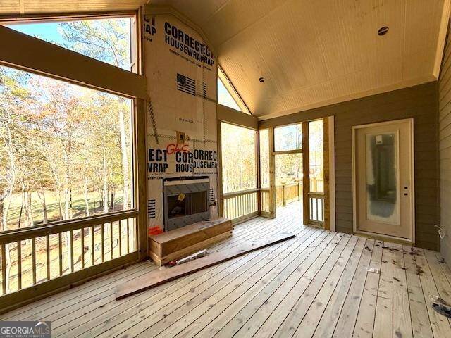 unfurnished sunroom with a healthy amount of sunlight, wood ceiling, and vaulted ceiling