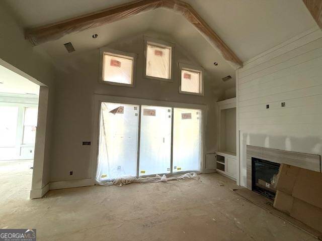 unfurnished living room featuring vaulted ceiling