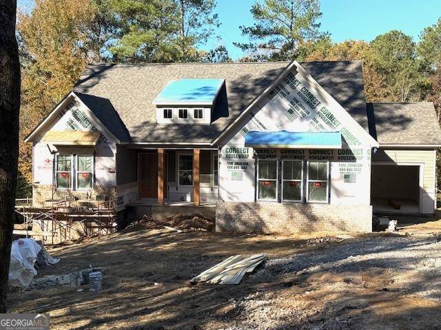 rear view of house featuring covered porch and a garage