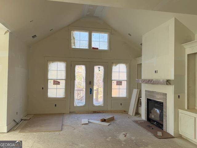 unfurnished living room with french doors and lofted ceiling