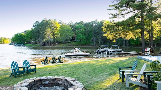 view of dock featuring a water view, a yard, and an outdoor fire pit