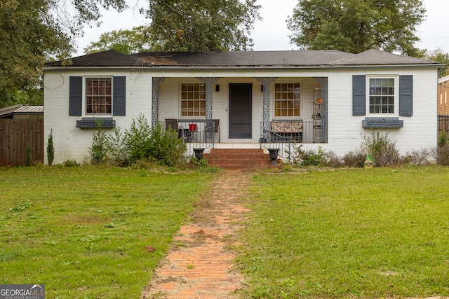 ranch-style house with covered porch and a front yard