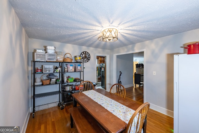 dining area with hardwood / wood-style floors and a textured ceiling