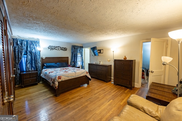 bedroom with wood-type flooring and a textured ceiling