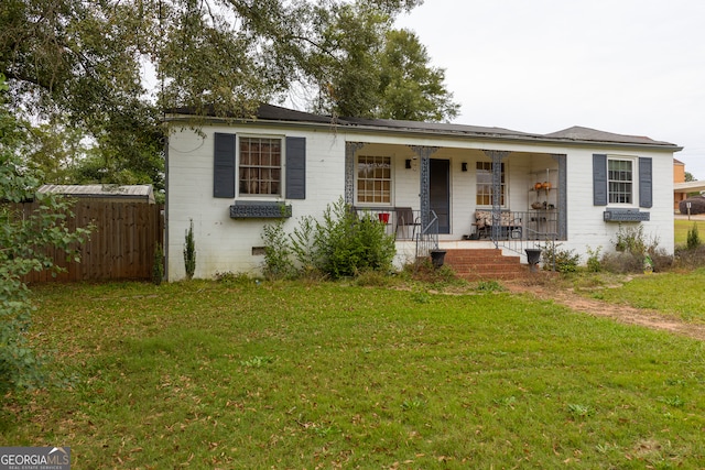 ranch-style home with covered porch and a front yard