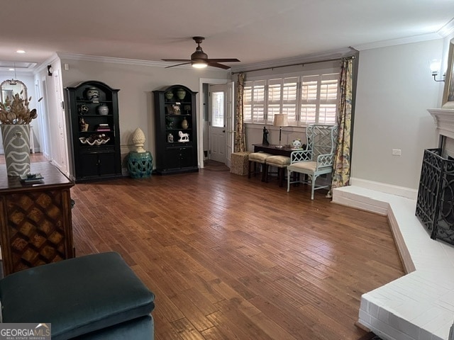 living room with crown molding, ceiling fan, and dark hardwood / wood-style floors