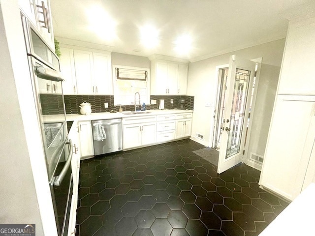 kitchen featuring decorative backsplash, white cabinetry, sink, and appliances with stainless steel finishes