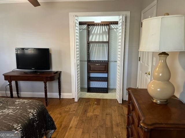 bedroom featuring dark hardwood / wood-style floors, ceiling fan, and a closet