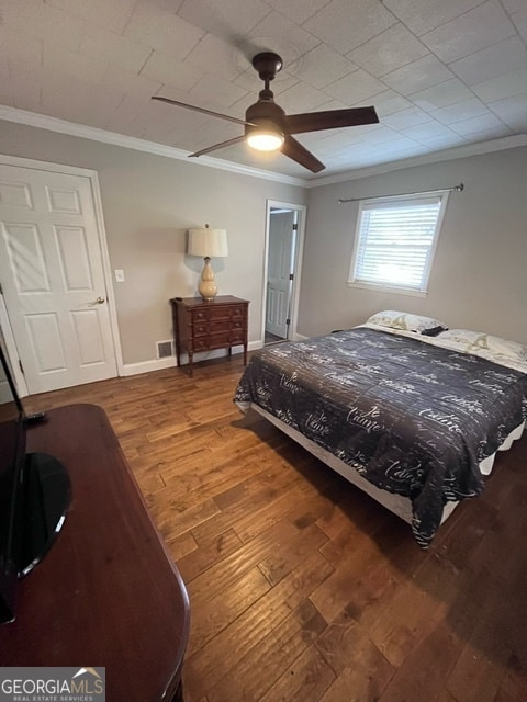 bedroom featuring hardwood / wood-style floors, ceiling fan, and ornamental molding