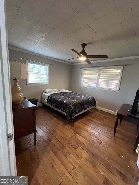 bedroom with multiple windows, ceiling fan, ornamental molding, and hardwood / wood-style flooring