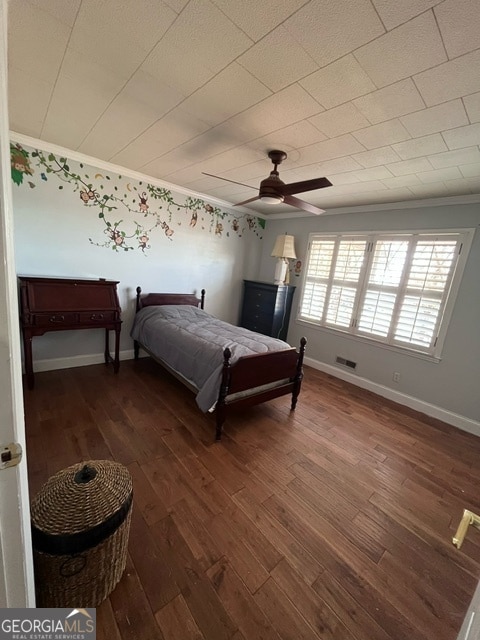 bedroom with dark hardwood / wood-style floors, ceiling fan, and ornamental molding