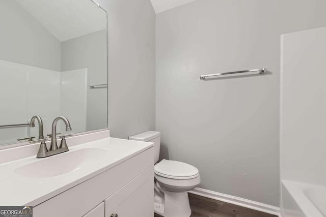 bathroom featuring wood-type flooring, vanity, and toilet