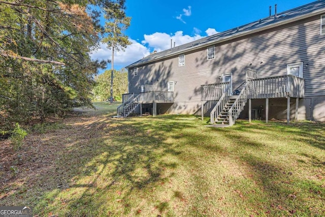 back of property with a yard and a wooden deck