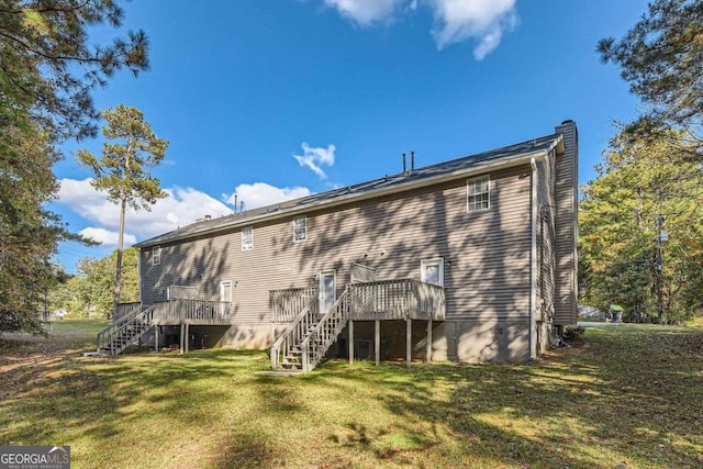 rear view of property with a yard and a wooden deck