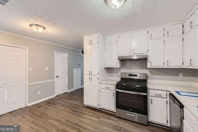 kitchen with dark wood-type flooring, white cabinets, crown molding, a textured ceiling, and stainless steel appliances