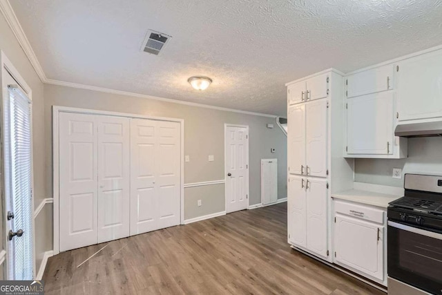 kitchen featuring crown molding, white cabinets, stainless steel range oven, and light wood-type flooring