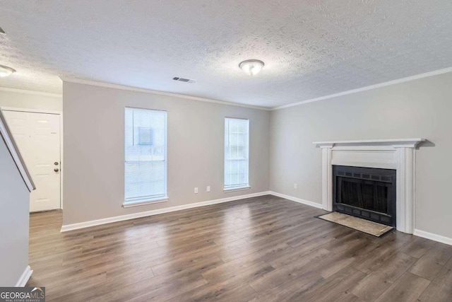 unfurnished living room with a textured ceiling, a wealth of natural light, and dark hardwood / wood-style floors