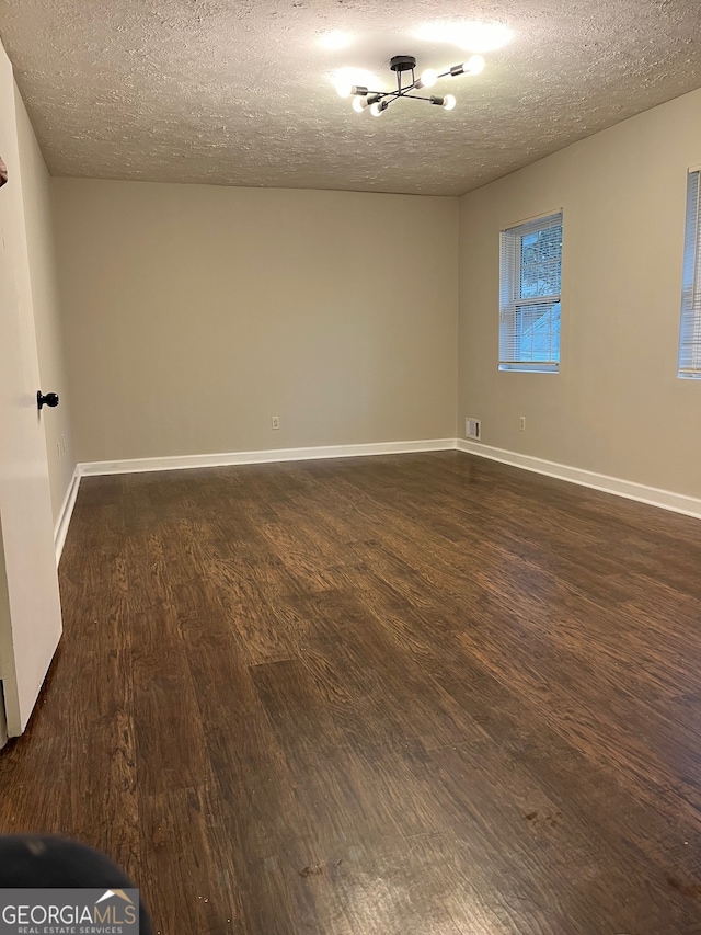 unfurnished room with dark hardwood / wood-style floors and a textured ceiling