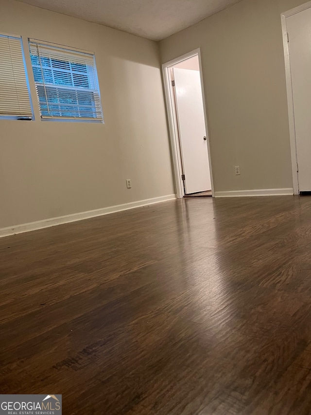 spare room with dark hardwood / wood-style floors