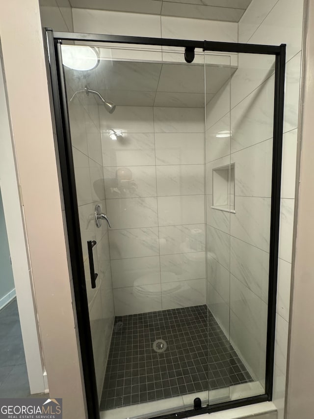 bathroom featuring a shower with door