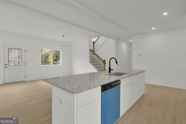 kitchen featuring white cabinetry, dishwasher, a center island with sink, and light hardwood / wood-style flooring