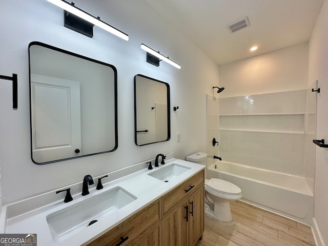 full bathroom with shower / washtub combination, vanity, wood-type flooring, and toilet