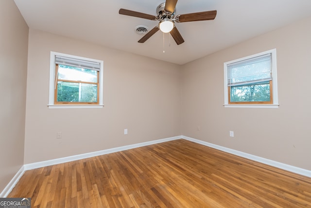 empty room with hardwood / wood-style floors and ceiling fan