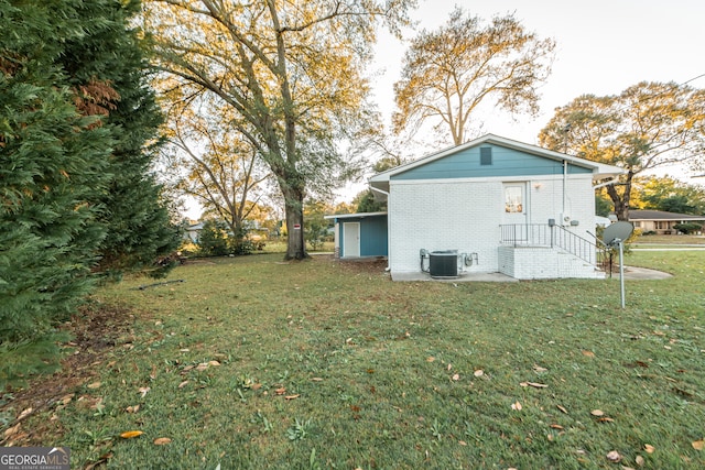 back of property with central AC and a yard