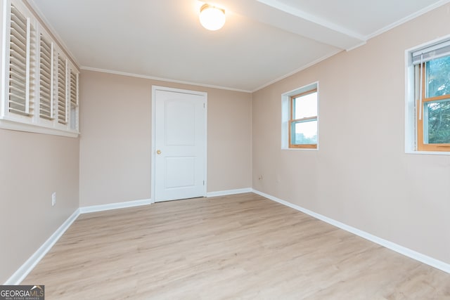 unfurnished bedroom featuring light hardwood / wood-style floors, multiple windows, and ornamental molding