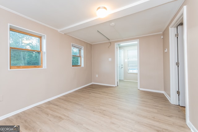 unfurnished room with light wood-type flooring and crown molding