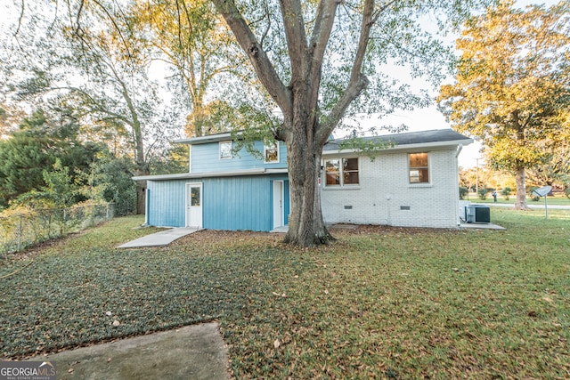 rear view of house with a lawn and central AC unit