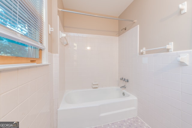 bathroom with tiled shower / bath, tile patterned floors, and tile walls