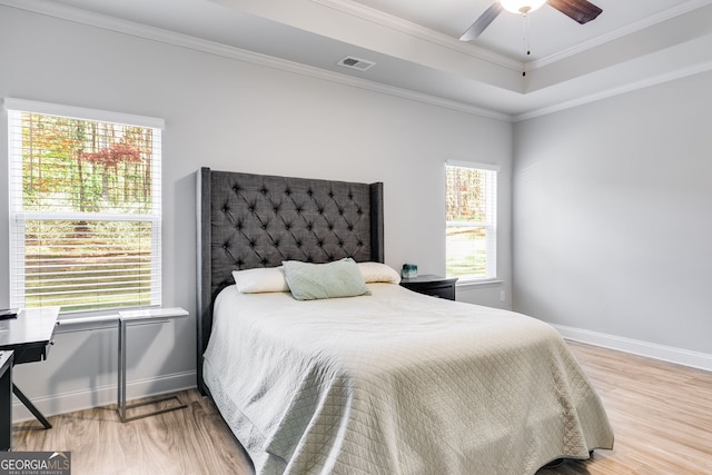 bedroom with light hardwood / wood-style flooring, ceiling fan, and crown molding