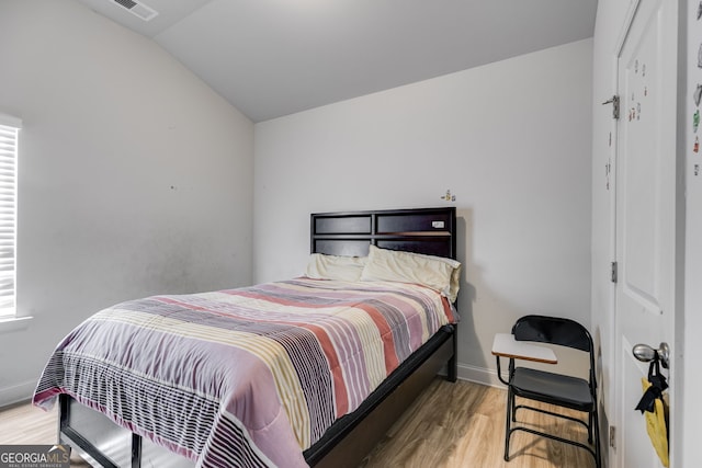 bedroom with light hardwood / wood-style floors and lofted ceiling