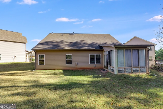 rear view of property with a lawn and a sunroom