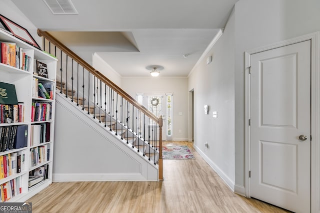 interior space featuring crown molding and light hardwood / wood-style floors