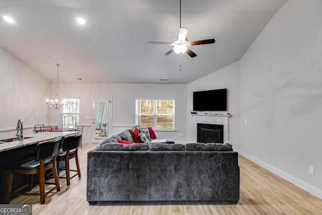 living room with a healthy amount of sunlight, lofted ceiling, and light wood-type flooring