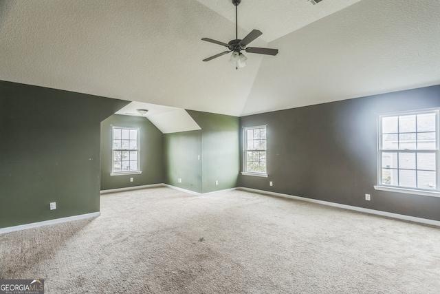 bonus room with ceiling fan, light colored carpet, a textured ceiling, and vaulted ceiling