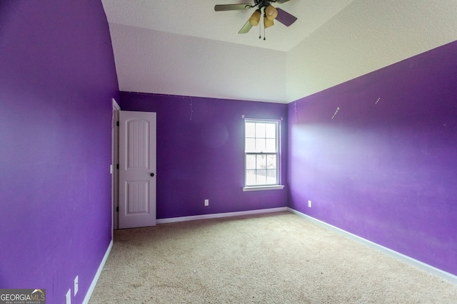 spare room featuring a textured ceiling, ceiling fan, light carpet, and lofted ceiling