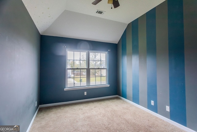 empty room with carpet flooring, ceiling fan, a textured ceiling, and vaulted ceiling